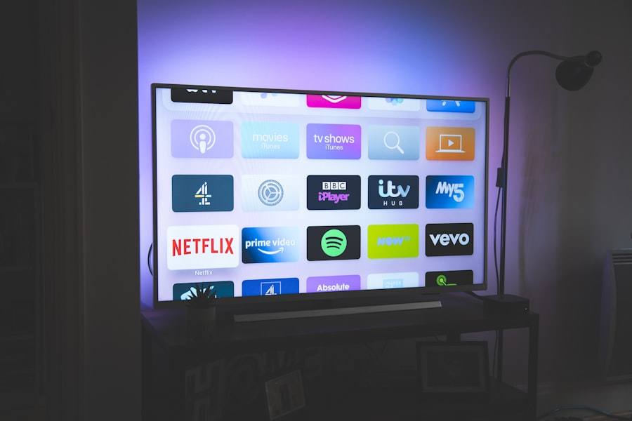 A flat-screen TV on a stand showing streaming app tiles, lit purple from behind