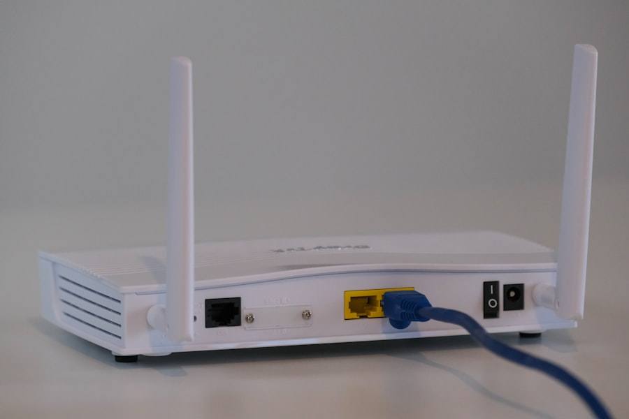 The back of a white router with two antennas and a blue network cable
